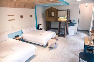 花蓮市にあるHappy Wing Guesthouseのベッド2台と二段ベッド1組が備わる客室です。