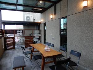 a dining room with a wooden table and chairs at Happy Wing Guesthouse in Hualien City
