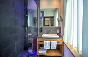 ein Badezimmer mit Waschbecken und Dusche in der Unterkunft Hotel am Hafen in Cochem