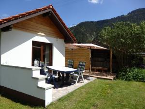 uma casa com uma mesa e cadeiras e um guarda-sol em Amsel Haus em Bayrischzell