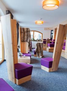 ツァウヘンゼーにあるHotel Enzian by Alpeffect Hotelsの紫色の椅子とテーブルが備わる広い客室です。 +39枚の写真