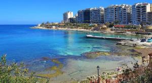 a view of a beach with buildings and the ocean at The Exiles Hotel in Sliema