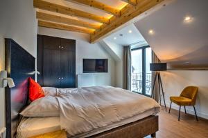 Hotel am Hafen في كوشيم: غرفة نوم بسرير كبير وكرسي