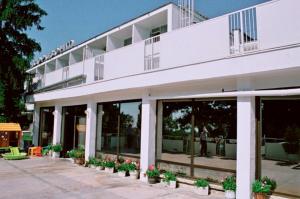 a white building with potted plants in front of it at Hotel Horizont in Golden Sands