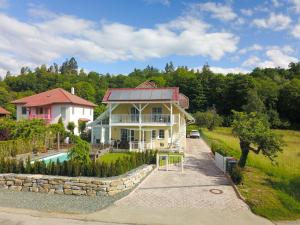 una casa con piscina frente a ella en Villa Schaller - Apartment, en Krumpendorf am Wörthersee