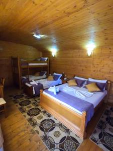 a bedroom with two beds in a wooden cabin at Hotel Bicaj in Shkodër