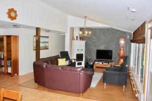 a living room with a brown leather couch and chairs at Kipinä Lomat - Majatalo Kipinä in Sotkamo