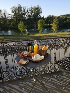 una bandeja de comida en una mesa sobre una valla de hierro forjado en Hotel de L'Oise en Saint-Leu-dʼEsserent