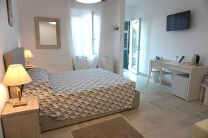 een slaapkamer met een bed, een tafel en een bureau bij Il Cavalluccio Marino in Manarola