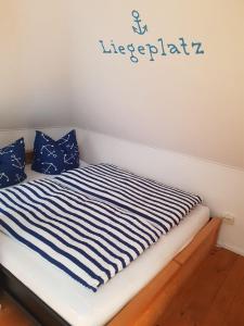 Una cama con sábanas de rayas azules y blancas. en Gemütliches eigenes Häuschen - optimal gelegen zwischen Altstadt und Hafen, en Senftenberg