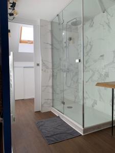 a shower in a bathroom with marble tiles at Duplex plein centre ville 3Etoiles in Le Mont-Dore +7 photos