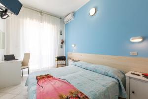 1 dormitorio con cama y pared azul en Hotel Sant'Angelo, en Riccione