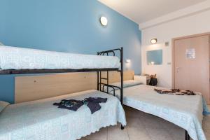 2 literas en una habitación con paredes azules en Hotel Sant'Angelo, en Riccione