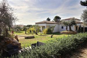 a house with a yard in front of it at La Villa Aux Oliviers in Flayosc