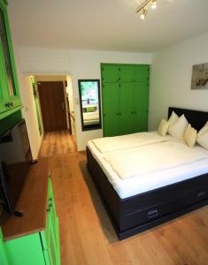 a bedroom with a large bed with green cabinets at Apartment Gastein in Bad Gastein