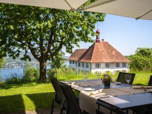 a dining table with a view of a church at Schloss Freudenfels in Eschenz