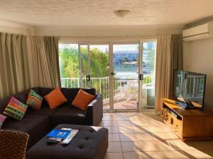 a living room with a couch and a tv at Pelican Cove Apartments in Gold Coast