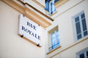 un panneau sur le côté d'un bâtiment dans l'établissement Royal Hotel Versailles, à Versailles