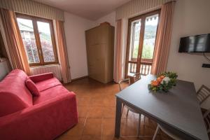 een woonkamer met een rode bank en een tafel bij Chalet Felse in Bormio