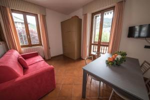 a living room with a red couch and a table at Chalet Felse in Bormio