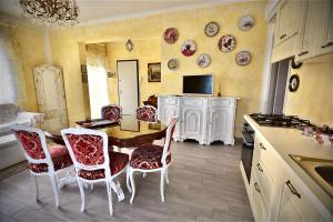 a kitchen with a table and chairs and plates on the wall at Le Bouganville Apartment in Desenzano del Garda