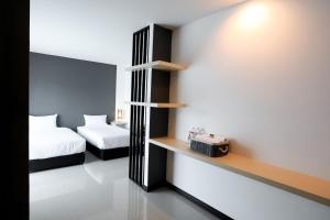 Rúm í herbergi á The Rest Hotel - ประจวบ