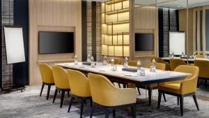Staybridge Suites Bangkok Thonglor, an IHG Hotel في بانكوك: قاعة المؤتمرات مع طاولة وكراسي طويلة