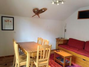 a dining room with a table and chairs and a couch at CHALET DE BOIS MEAN in Les Orres