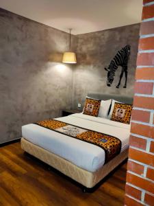 een slaapkamer met een bed met een zebraschilderij aan de muur bij 9 Square Hotel - Subang in Subang Jaya