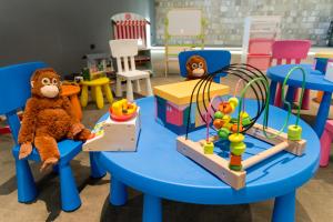 two stuffed animals sitting on a blue table in a play room at Hotel Crni Vrh in Divčibare