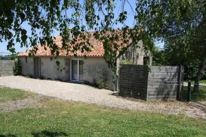 une petite maison avec une clôture devant elle dans l'établissement Gîte de La Brenelière, à Cirière