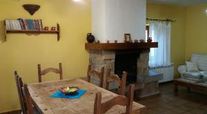 comedor con mesa y chimenea en La Casa de la Abuela, en Casas del Monte