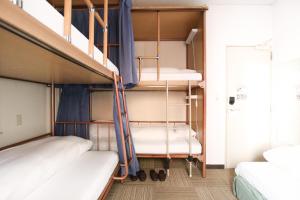 a room with three bunk beds and a staircase at Sakura Hotel Jimbocho in Tokyo