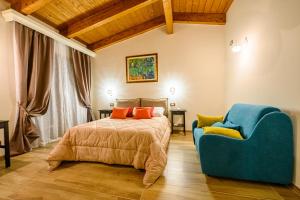 a bedroom with a bed and a blue chair at Casa de Campo B&B in San Giovanni Teatino