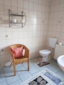 ein Badezimmer mit einem Korbstuhl und einem WC in der Unterkunft Fewo am Achterwasser in Zempin + 6 Fotos