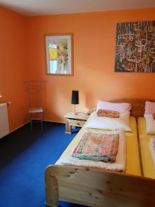 ein Schlafzimmer mit 2 Betten und einer orangefarbenen Wand in der Unterkunft Fewo am Achterwasser in Zempin