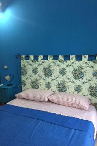 um quarto azul com uma cama com 2 almofadas em Sulle orme di Federico II em Rocca Imperiale