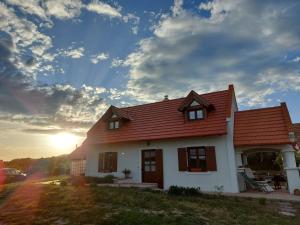 ein weißes Haus mit rotem Dach mit Sonnenuntergang in der Unterkunft Casa Beata in Lesencetomaj