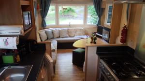 a living room with a couch in a caravan at Ferienhaus direkt am See Mobilheim am Schönsee in Urnshausen