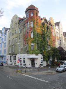 un edificio alto con hiedra en una calle en Hotel Haus Martens, en Hannover