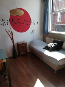 1 dormitorio con cama y ventana en Simplon Hostel, en Groninga