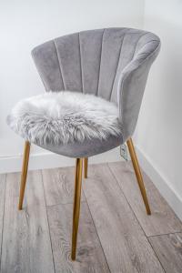 una silla gris con asiento peludo y patas de madera en Millburn Apartment en Inverness