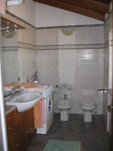 a bathroom with a sink and a washing machine and a toilet at Residence La Bellotta in Oleggio