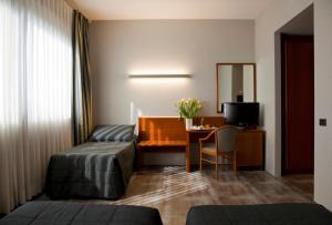 una camera d'albergo con letto, scrivania e tavolo di Hotel Zone a Roma