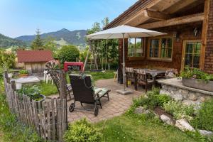 a patio with an umbrella and a table and chairs at Ferienhaus Bach Gotthard in Pfronten