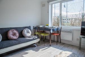 a living room with a couch and a table with chairs at Millburn Apartment in Inverness