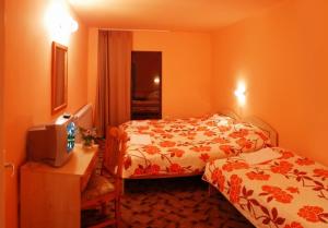 a hotel room with two beds and a television at Tourist center Momina Krepost in Veliko Tŭrnovo