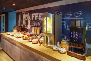 uma linha de buffet com uma máquina de café e comida em ibis budget London Barking em Barking