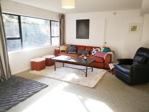 - un salon avec un canapé et une table dans l'établissement Park to Mountains Apartment, à Arrowtown