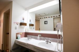 a bathroom with two sinks and a large mirror at Sakura Hotel Jimbocho in Tokyo